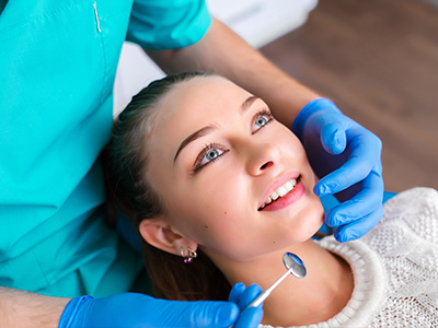 A dental professional is performing a teeth cleaning procedure on a patient.
