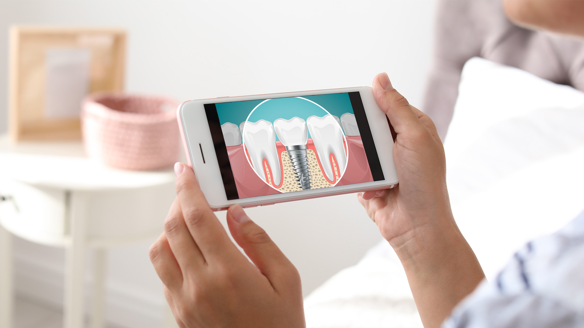 Person holding a smartphone displaying an image of a tooth with a magnified view of the gumline.