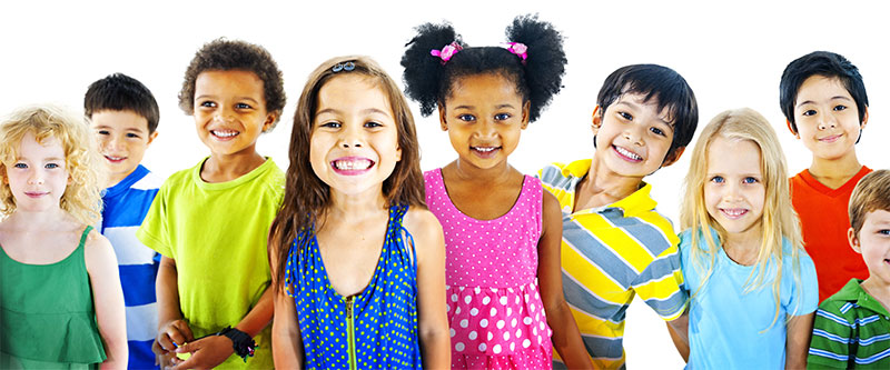 The image shows a diverse group of children and adults posing together with smiles, against a plain background.